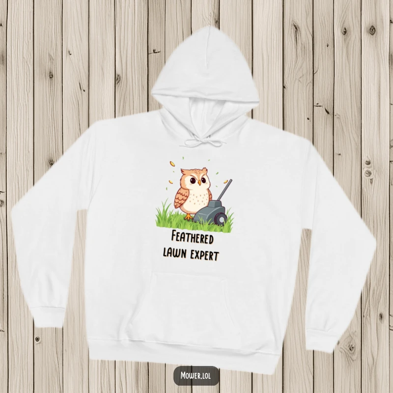 Funny, content owl watching grass clippings fly from the back of a lawn mower, featured on a warm, cozy hoodie, a humorous present.